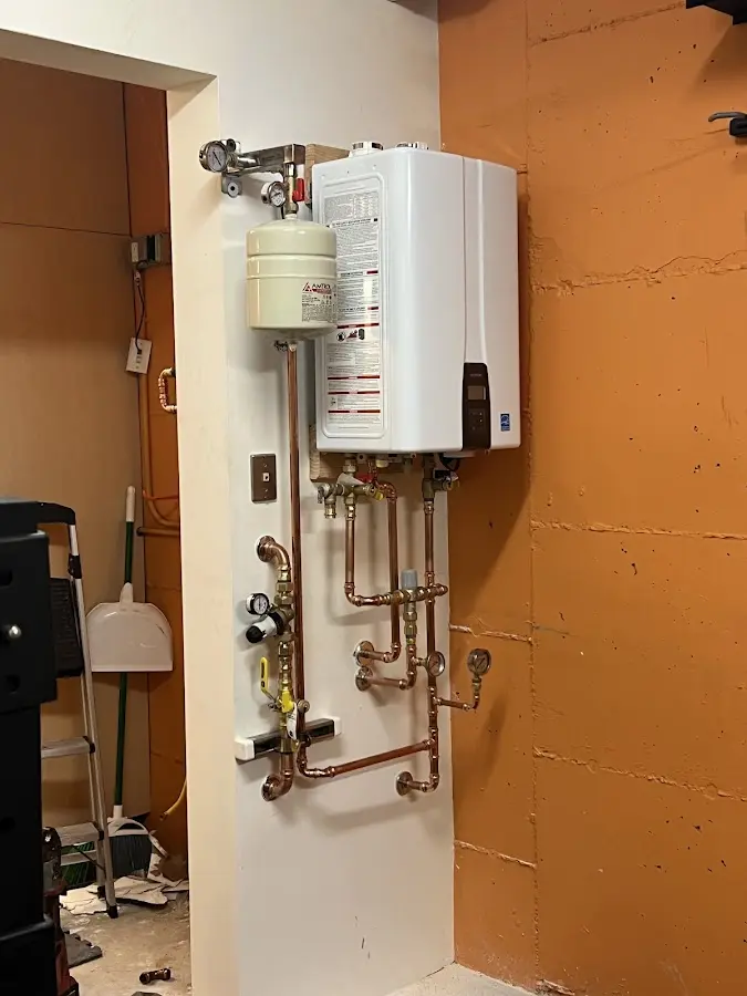Plumbing technician inspecting water heater connections in Concord
